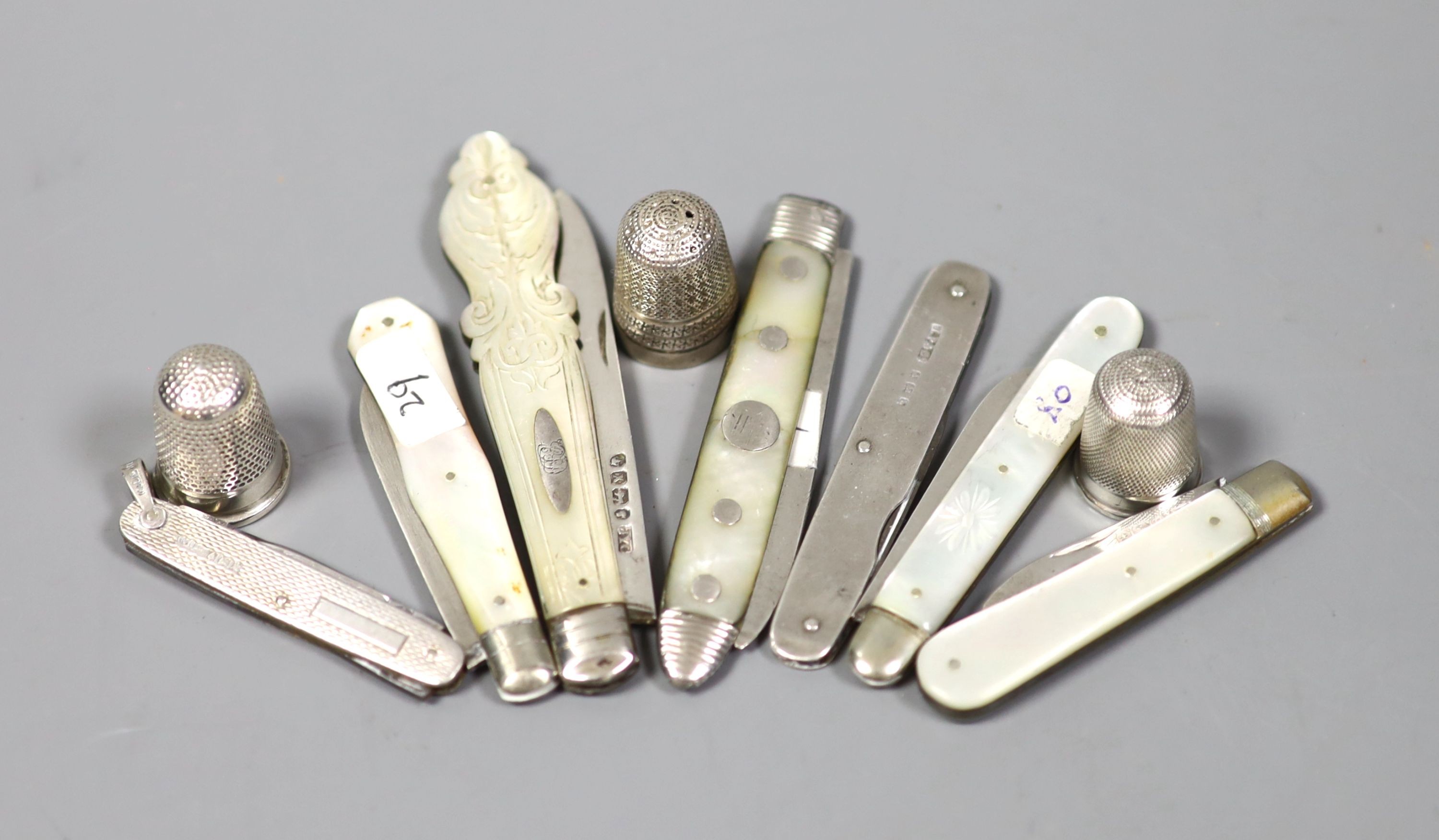 Seven assorted mother of pearl handled silver fruit knives and a penknife and three silver thimbles.